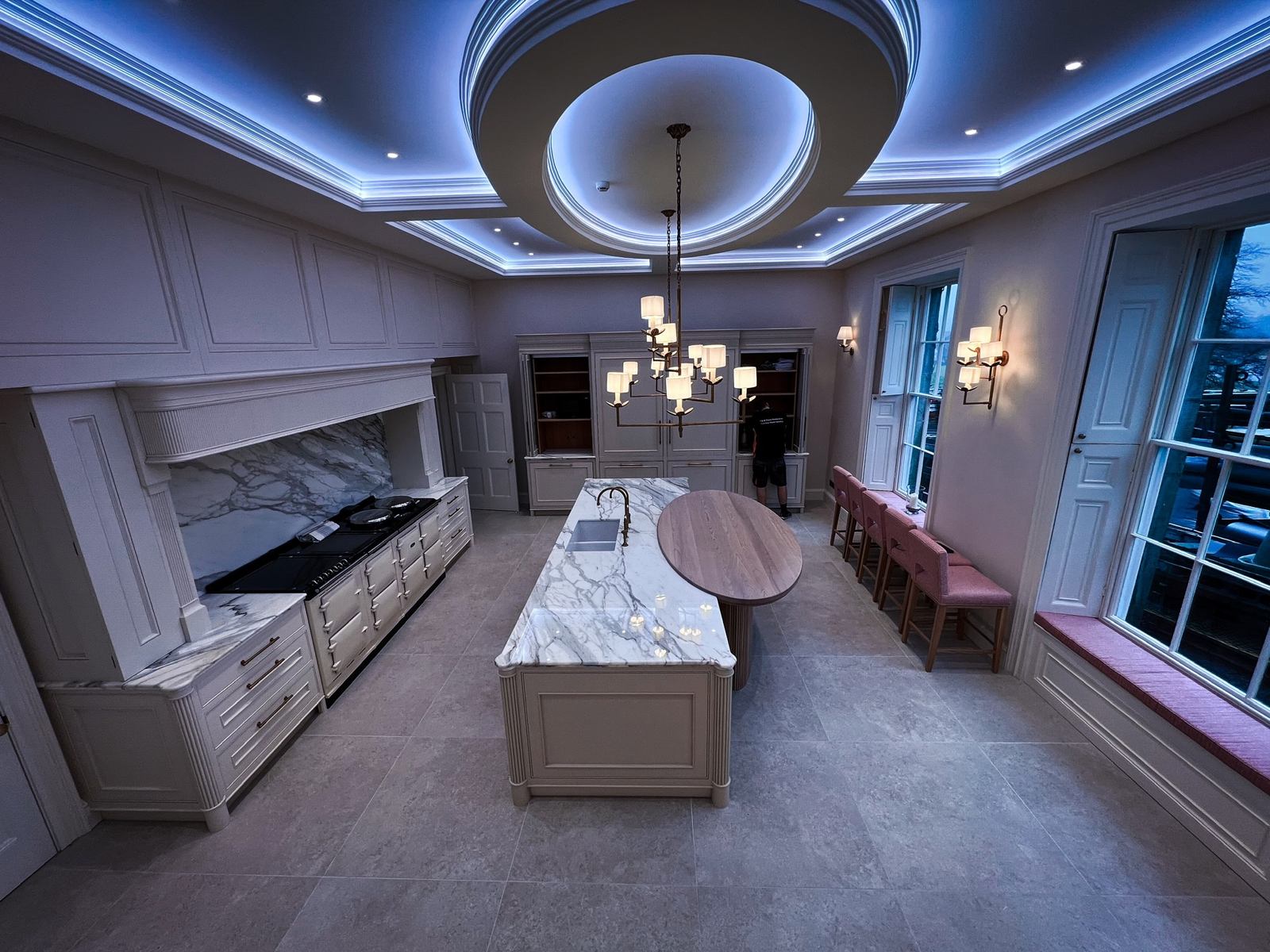 Long marble kitchen island under a lit ceiling dome